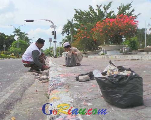 Bermodalkan Sendok Semen, Pria Ini Ajak Anaknya Umur 9 Tahun Bersihkan Kerak Lilin yang Kotori Tugu Perjuangan Pekanbaru