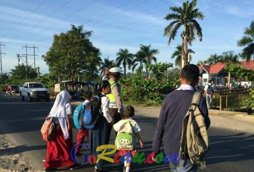 Polisi di Mandau Ini Bantu Ribuan Pelajar Menyebrang Jalan Lintas Setiap Pagi Dihari Sekolah