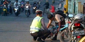 GoRiau Ini Contoh Polisi Baik, Bantu Anak Sekolah Pasangkan Rantai Sepeda