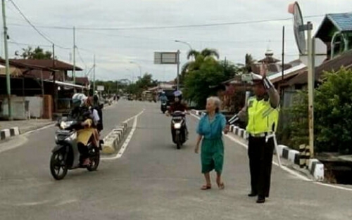 Cegah Kecelakaan Pejalan Kaki, Bripka Syopiyan Hadi Bantu Seorang Nenek Menyeberang