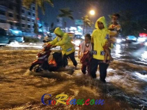 Kisah Menyentuh Polantas Pekanbaru Tanpa Alas Kaki Tolong Ibu dan 2 Anaknya yang Kedinginan Terjebak Banjir di Jalan